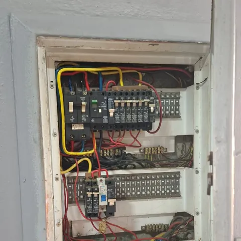 An open distribution board with its breakers and wiring