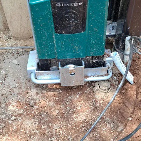 A gate motor mounted on its base plate beside a sliding gate