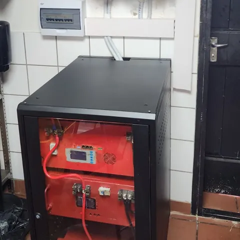 A battery cabinet standing under a wall-mounted unit