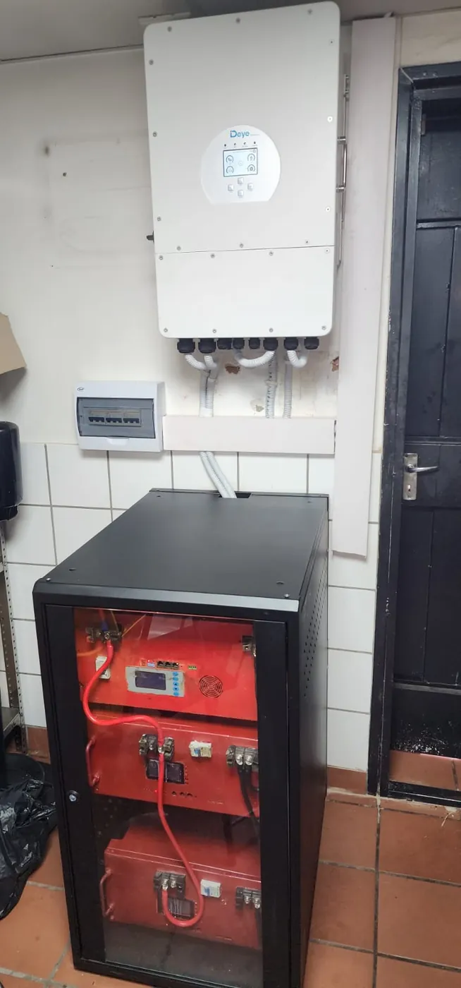 A battery cabinet standing under a wall-mounted unit